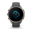 A Garmin fēnix 9 Pro inReach multisport GPS smartwatch with a gray band displays a blue-lit screen featuring a play button, a phone icon, and a microphone symbol in the center.