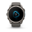A Garmin fēnix 9 multisport GPS smartwatch with a gray band features a vibrant AMOLED display showing a glowing blue play icon and a smartphone with a microphone symbol.