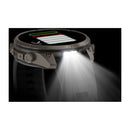 The Garmin fēnix 9 Pro inReach multisport GPS smartwatch is shown with its integrated flashlight feature activated, emitting a powerful side beam against a dark background. The display highlights battery status and advanced satellite connectivity, ensuring reliable tracking in any environment.