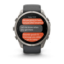 A Garmin fēnix 9 Pro inReach multisport GPS smartwatch displays a text conversation about heading out after breakfast and coordinating arrival at camp. Featuring a round face, side buttons, and a dark band, the watch also offers advanced satellite connectivity for reliable messaging—even in remote areas.