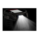 The Garmin fēnix 9 is a black multisport GPS smartwatch with an AMOLED display, featuring a rectangular light on its face that shines a bright white beam to illuminate the surrounding area in the dark.