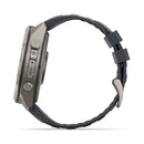 Side view of a gray Garmin fēnix 9 Pro inReach multisport GPS smartwatch with a black textured band, featuring two visible buttons and a sleek, modern design. The buckle and strap loops appear on the right side, emphasizing the watch’s advanced features such as satellite connectivity.