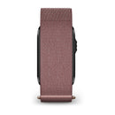 A close-up view of the Garmin CIRQA Smart Band with a textured, mauve-colored strap is shown from the side, emphasizing the band and the edge of the watch face; it features advanced sleep tracking and 24/7 health monitoring for a comprehensive wellness experience.