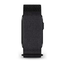 A black CIRQA Smart Band by Garmin is shown from the side, its face mostly concealed by a dark, textured fabric band fastened with Velcro. The digital crown on the right hints at advanced sleep tracking and 24/7 health monitoring features beneath its understated design.