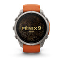 A Garmin fēnix 9 Pro inReach multisport GPS smartwatch with an orange wristband, featuring a round screen displaying a topographic map design and the text “FENIX 9 PRO.”.