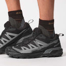 Black and gray Salomon hiking shoes with socks on a white background