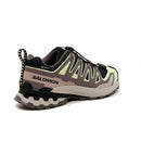 The Salomon Womens XA Pro 3D V9 GORE-TEX Trail Shoe in black, grey, and light green is shown from a rear-side angle, with a rugged sole for technical terrain, a pull tab, and SALOMON branding on the heel.