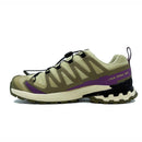 The Salomon Womens XA Pro 3D V9 GORE-TEX Trail Shoe features beige and olive green uppers, black accents, purple details, a rugged black-and-white sole, yellow XA PRO 3D text, and a quick-lace system—built for technical terrain.