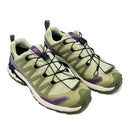 The Salomon Womens XA Pro 3D V9 GORE-TEX Trail Shoe in light olive and beige, featuring purple accents, black quick-lace system, and textured soles for technical terrain, is shown against a white background.