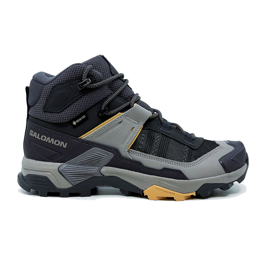 The image displays a side profile of the Salomon Womens X-Ultra 5 Mid GORE-TEX Hiking Boot in gray and black with yellow accents, a rugged sole, breathable mesh panels, reinforced toe, and Matryx upper against a white background.