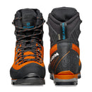 Two pairs of Scarpa Men’s Mont Blanc Pro GTX hiking boots in black and orange are positioned side by side, one facing forward and the other facing backward, highlighting their laces, soles, and prominent brand logos. These technical mountaineering boots are engineered for optimal performance and support on challenging terrain.