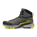 The Scarpa Men’s Rush TRK GORE-TEX hiking boot, shown in side profile on a white background, features a gray and black design with yellow accents and laces, a rugged sole, and excellent ankle support.